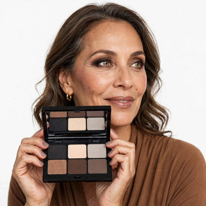 A woman holding an 8thereal 6-shade eyeshadow palette with neutral matte and shimmer tones for a versatile eye look.