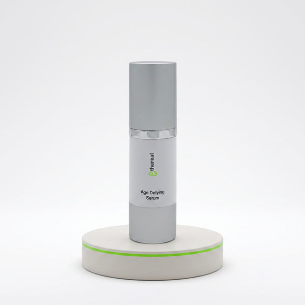 8thereal Age-Defying Facial Serum in a sleek silver pump bottle displayed on a minimalist white pedestal.