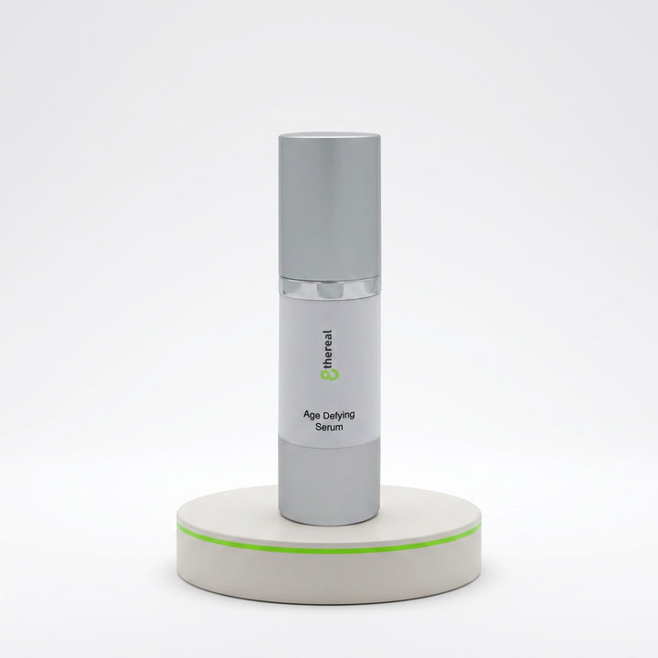 8thereal Age-Defying Facial Serum in a sleek silver pump bottle displayed on a minimalist white pedestal.