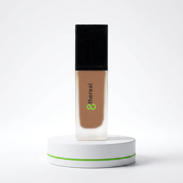8thereal lightweight foundation with SPF in a glass bottle on a white display stand against a clean background
