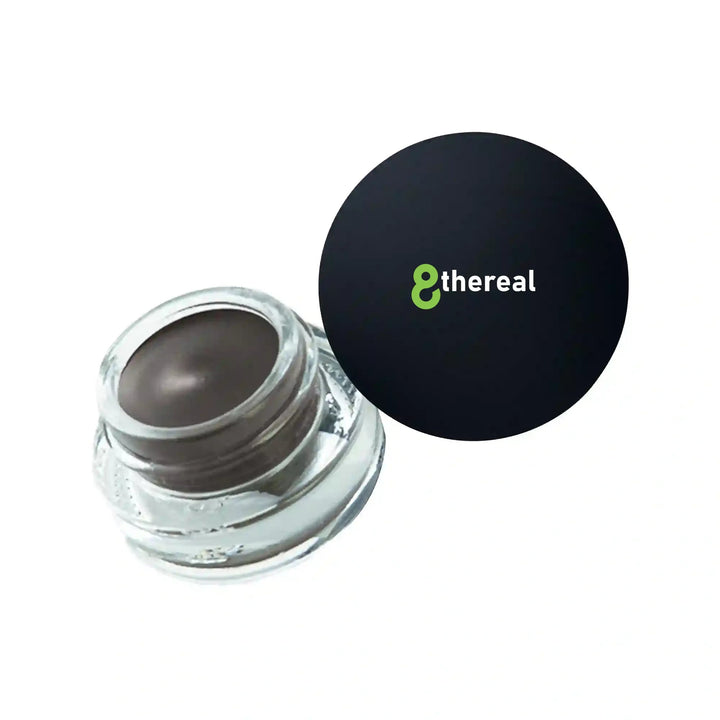 8thereal Soft Sculpt Brow Pomade in a small glass jar with a black lid, featuring a creamy matte brown formula.