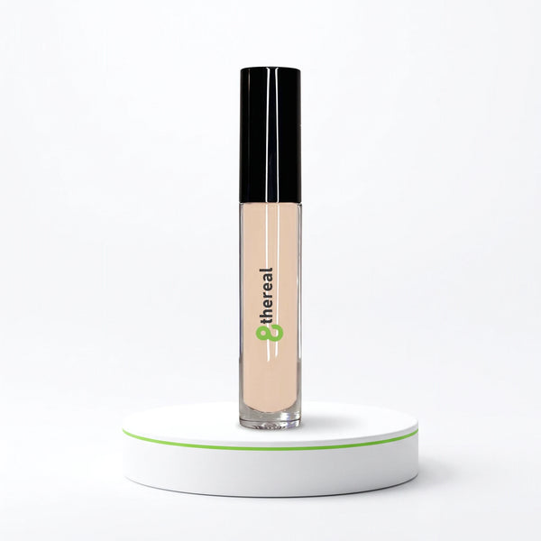 8thereal cream concealer in a clear tube with a black cap, standing on a white circular pedestal against a white background.
