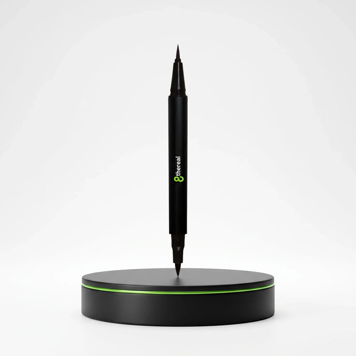 8thereal dual tip eye definer pen in jet-black standing vertically on a circular black base with green trim.