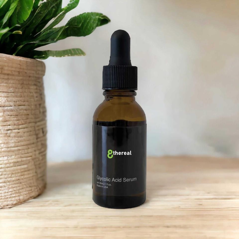 8thereal Glycolic Acid Serum in a brown glass dropper bottle on a wooden surface next to a potted plant.