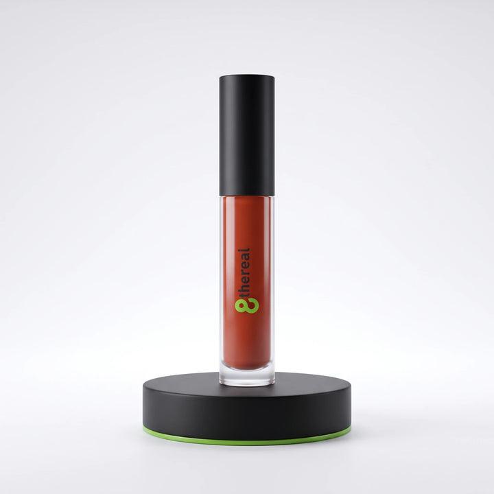 8thereal high-shine lip gloss in a terracotta shade with a black cap, displayed upright on a black circular stand.