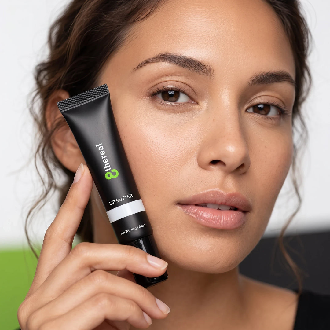 8thereal hydrating lip butter in a black squeeze tube held by a woman with natural makeup and glowing skin