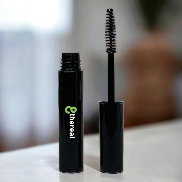 8thereal Lash Rejuvenator clear serum in a black tube with a spoolie wand applicator for nourishing lashes and brows.