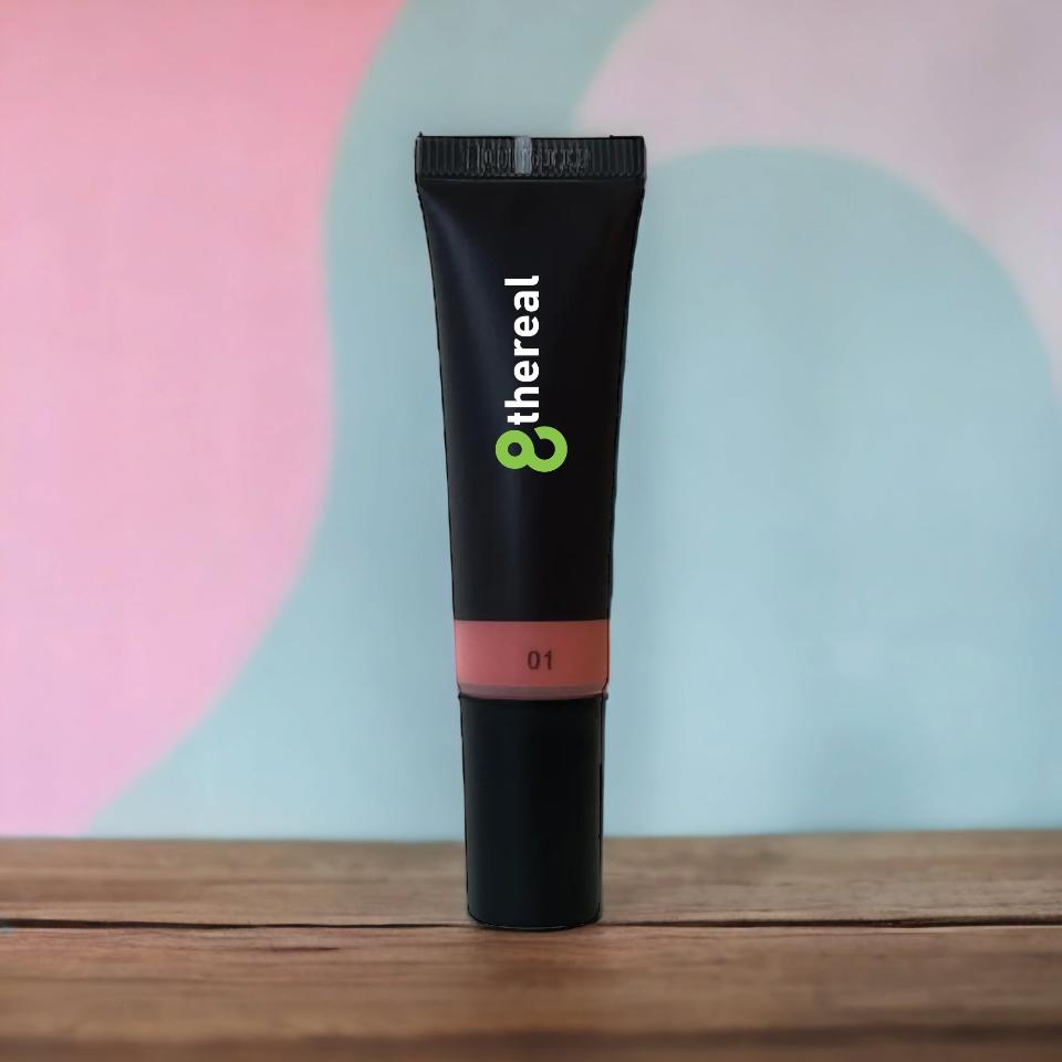 8thereal Soft Flush liquid blush in a black squeeze tube with a soft pink shade, standing on a wooden surface.
