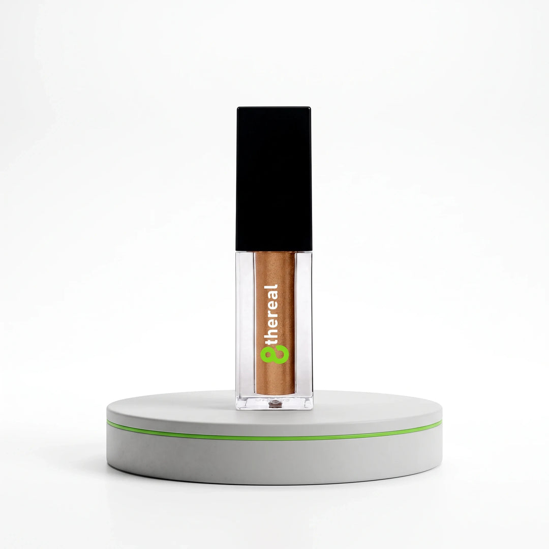 8thereal Liquid Radiance Shimmer in a clear glass bottle with a black cap, featuring a bronze liquid highlighter.