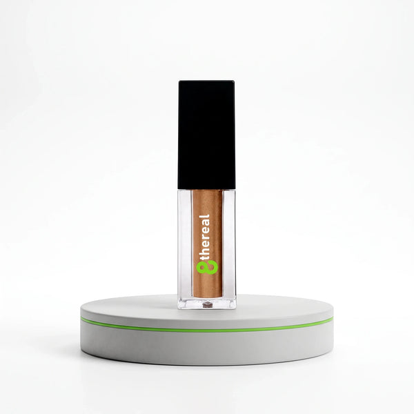 8thereal Liquid Radiance Shimmer in a clear glass bottle with a black cap, featuring a bronze liquid highlighter.