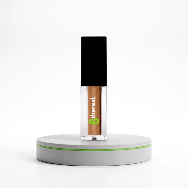 8thereal Liquid Radiance Shimmer in a clear glass bottle with a black cap, featuring a bronze liquid highlighter.