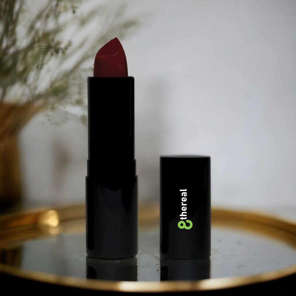 8thereal luxury matte lipstick in a deep red shade with sleek black packaging on a gold tray