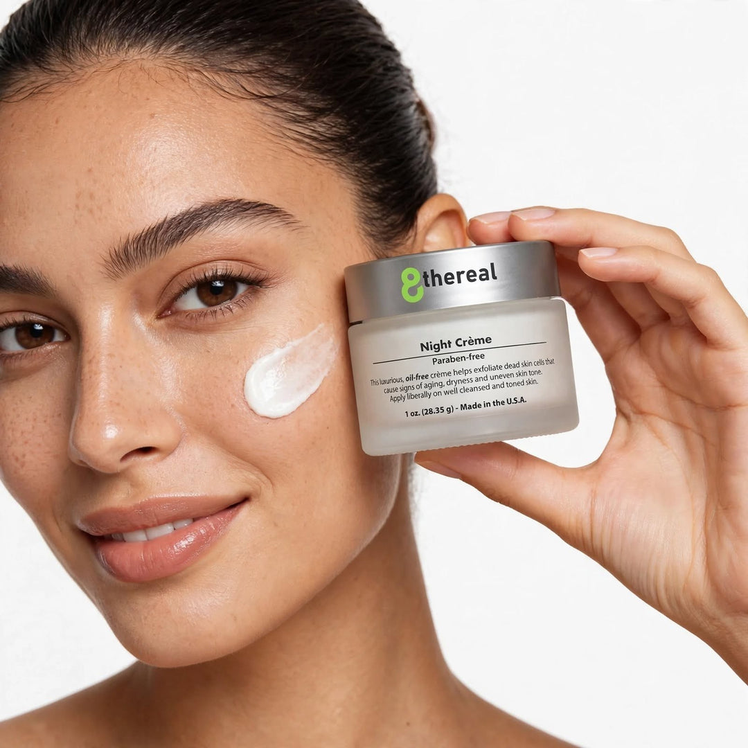 8thereal Night Skin Renewal Crème held by a woman with a dab of white moisturizing cream on her cheek