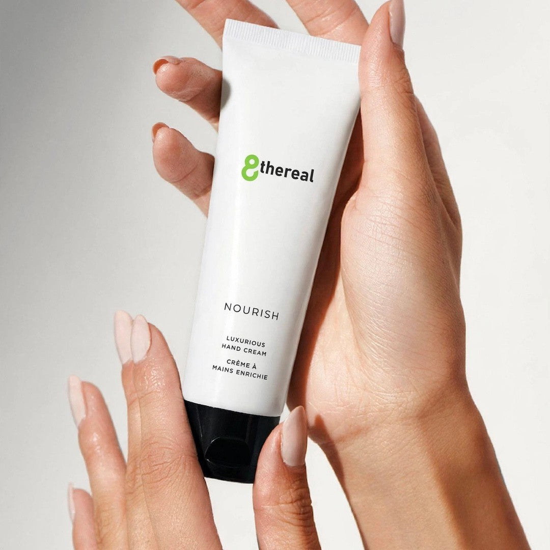 8thereal Restorative Nourish Hand Cream in a white squeeze tube held by hands, featuring a clean, minimalist design.