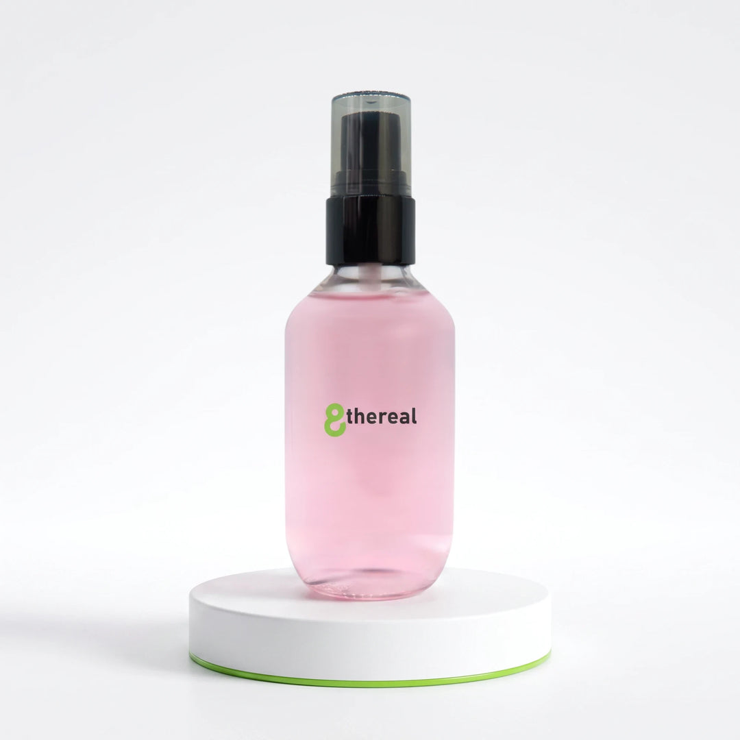 8thereal oil control setting spray in a clear pink bottle with a black pump on a white circular display stand.