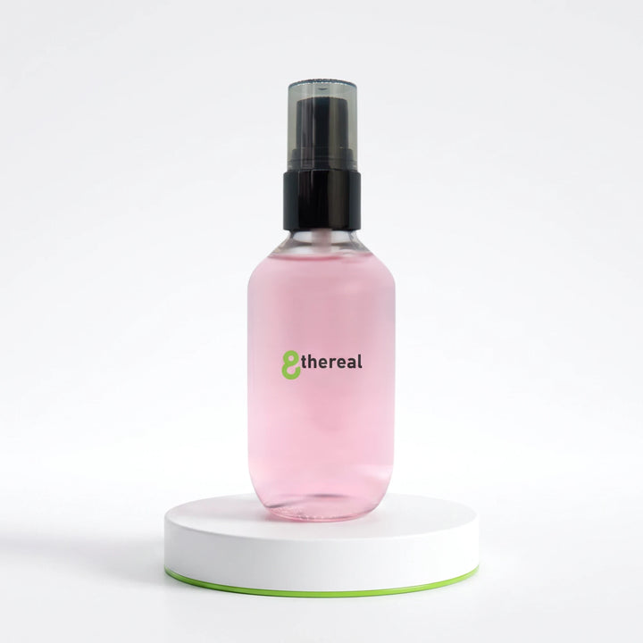 8thereal oil control setting spray in a clear pink bottle with a black pump on a white circular display stand.