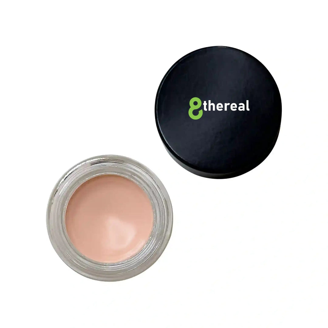 8thereal smoothing eye and lip primer in a small glass jar with a black lid, featuring a silky beige cream formula.