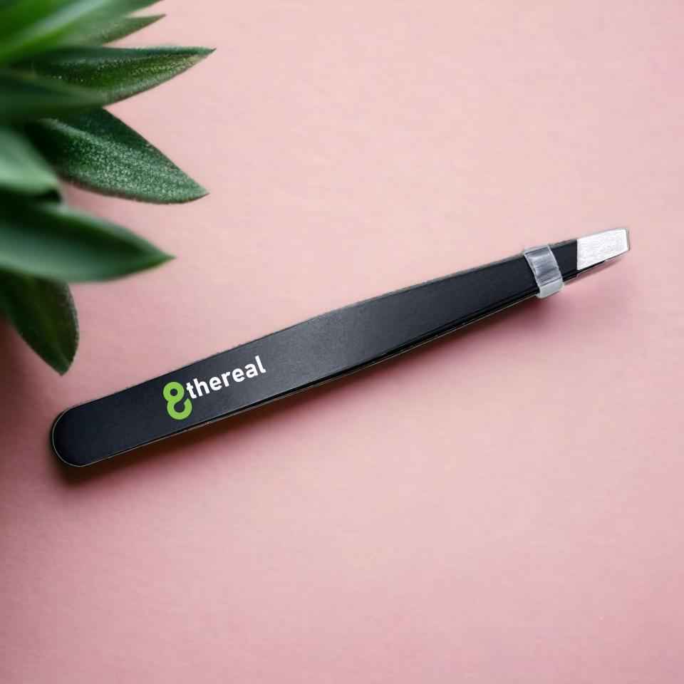 8thereal stainless steel precision tweezers with slanted tips for brow grooming on a soft pink background.