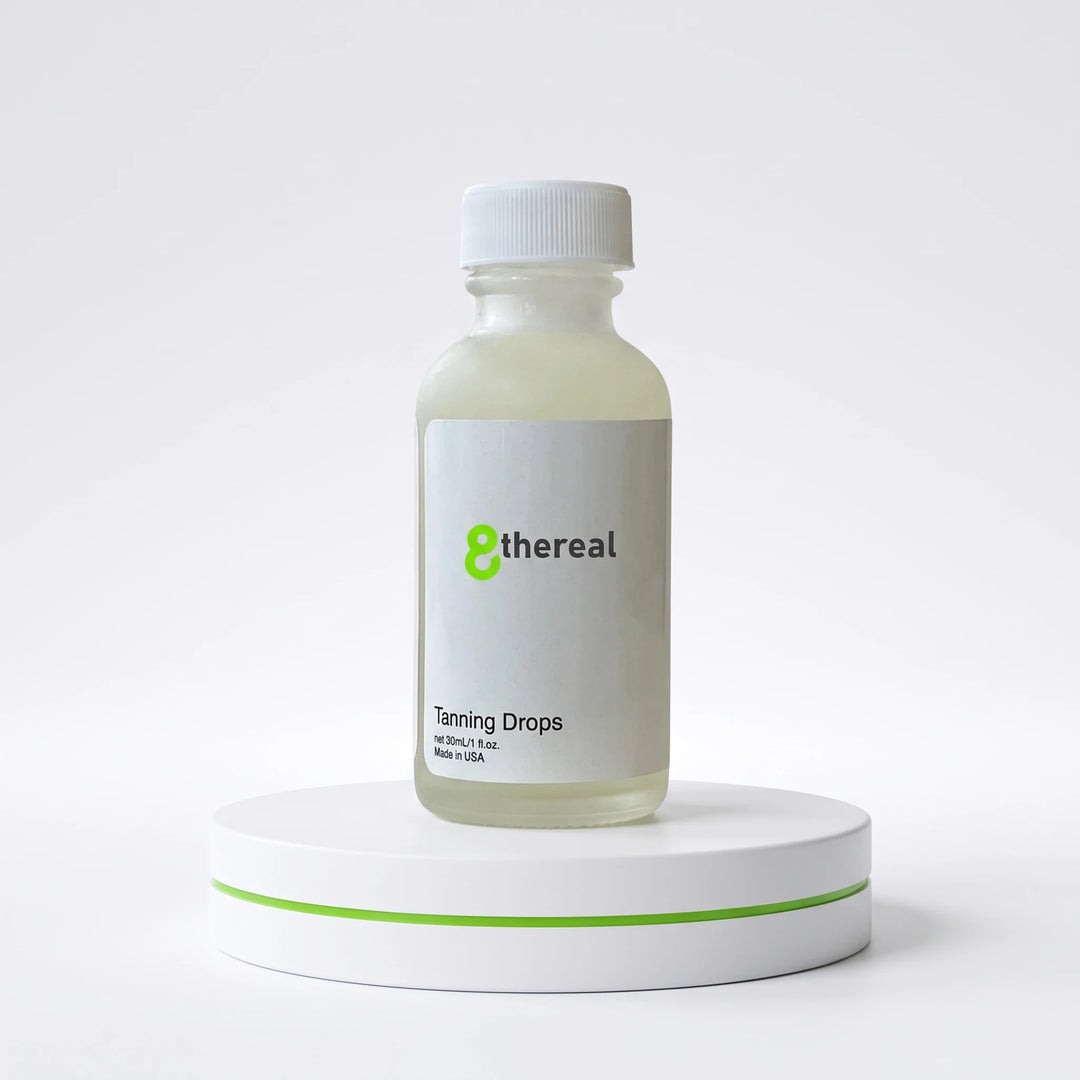 8thereal Sunlit Glow Tanning Drops in a clear glass bottle with a white cap, displayed on a white pedestal.