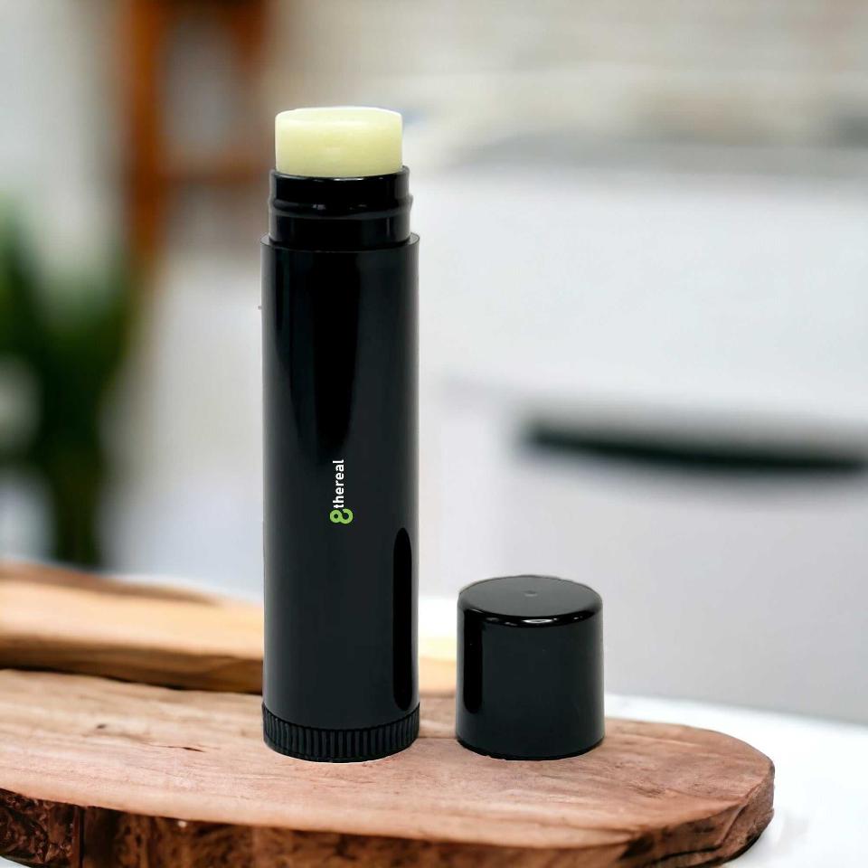 8thereal vegan lip balm in a sleek black tube with the cap off, resting on a rustic wooden surface.