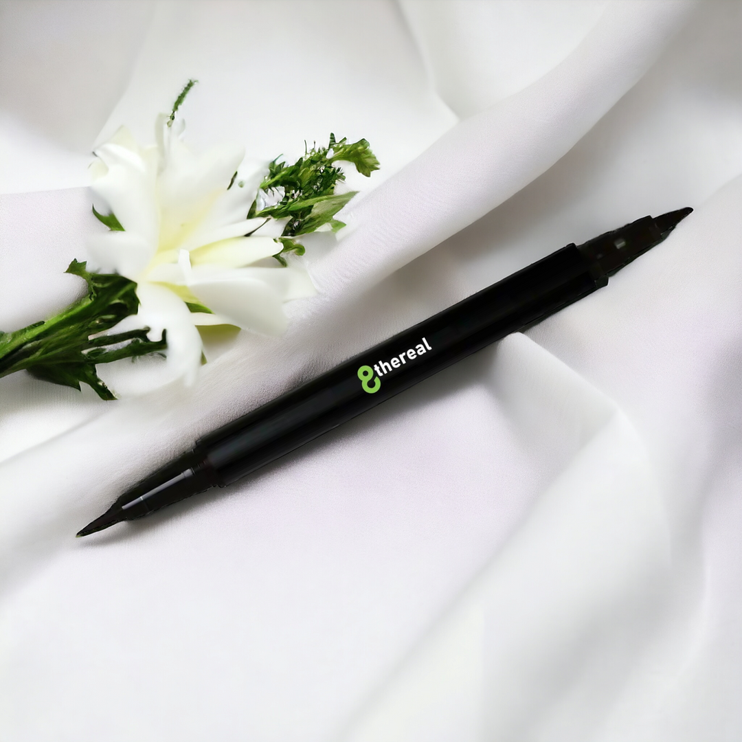 How To Use A Dual Tip Eye Definer Pen |Dual tip eye definer pen on white linen with a white flower sitting above it.